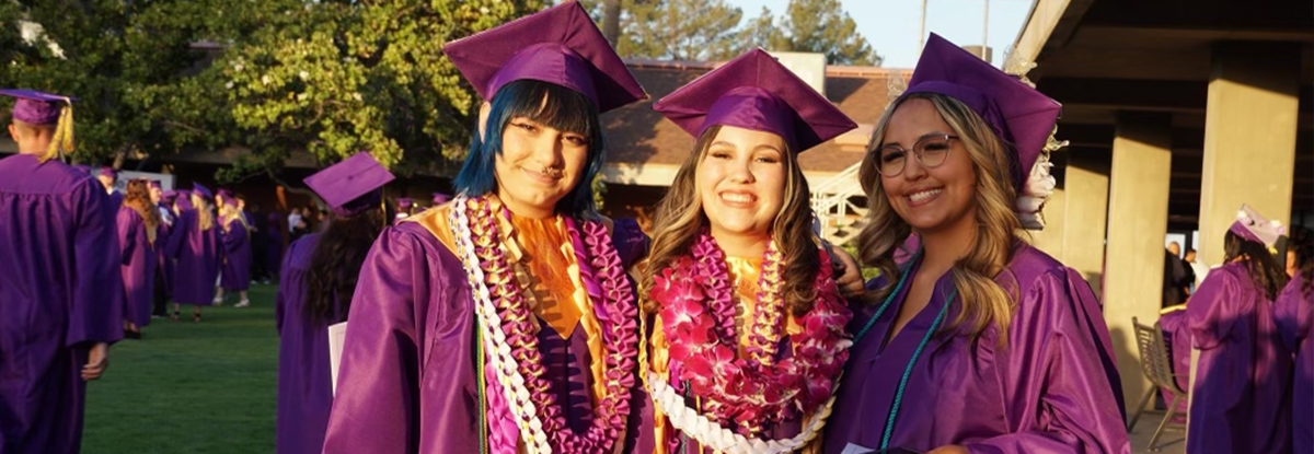 Three happy girls at graduation in their cap and gowns